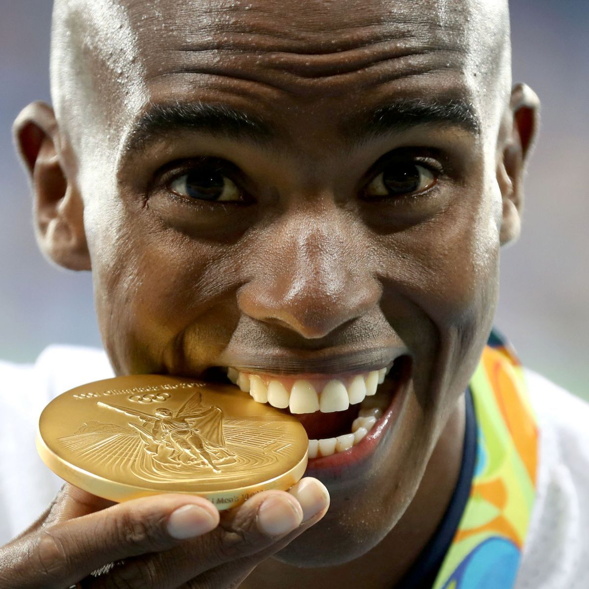 Atleta morde a medalha de ouro para testar a veracidade desse metal dessa maneira.