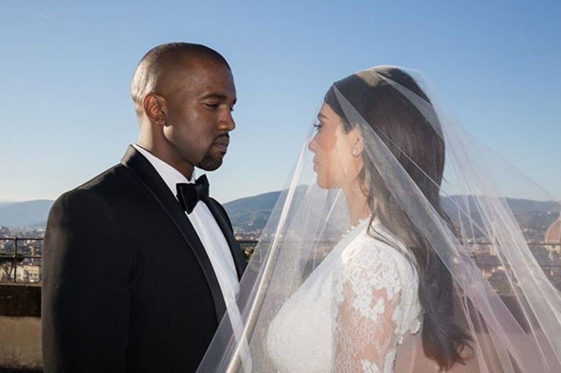 Kanye west e kim kardashian se olhando durante a cerimônia de casamento.