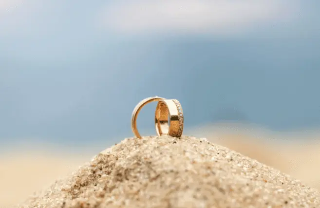 Qual a diferença entre alianças maciça, banhada ou folheada? - aliancas-praia-areia