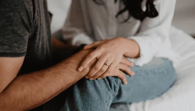 10 sinais do homem que quer ou não casar com você - casal-sentado-na-cama-maos-dadas-alianca