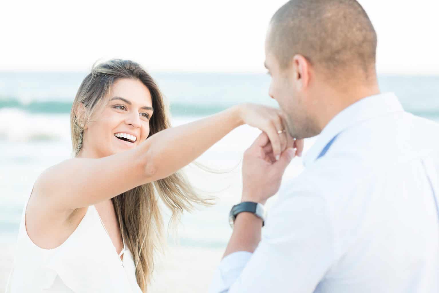 Homem beijando a mão de sua noiva, após o pedido de casamento