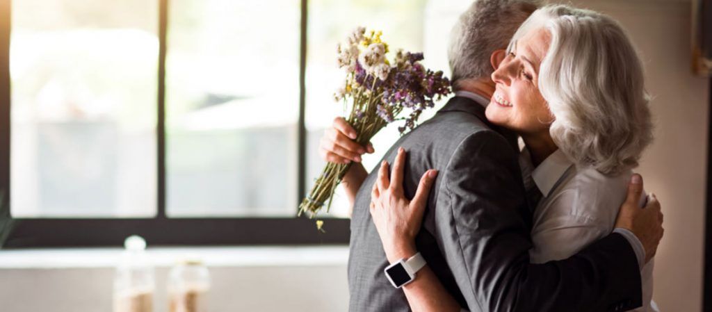 Casal de idosos se abraçando e comemorando bodas