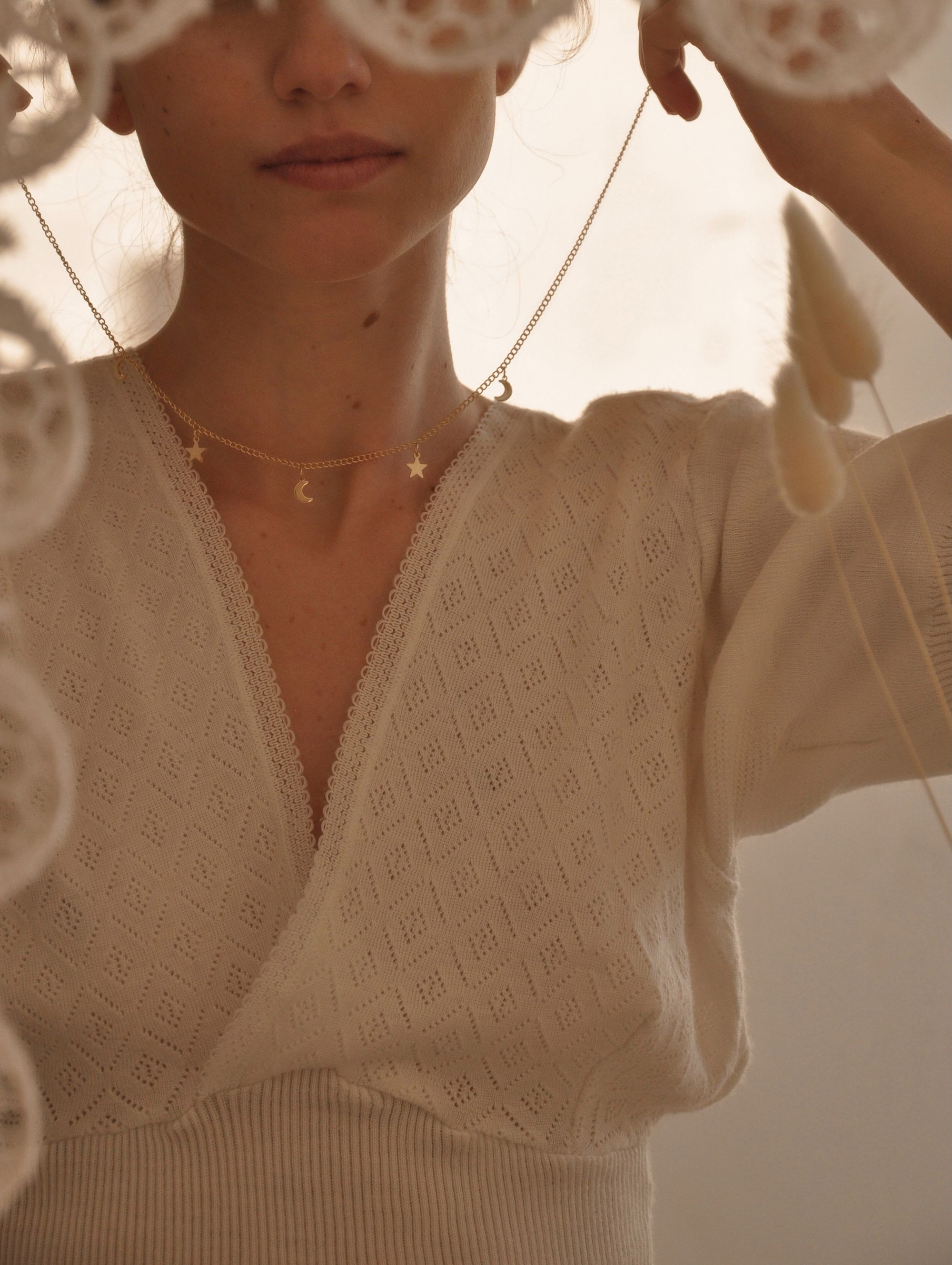 Foto de mulher colocando colar em si mesma.