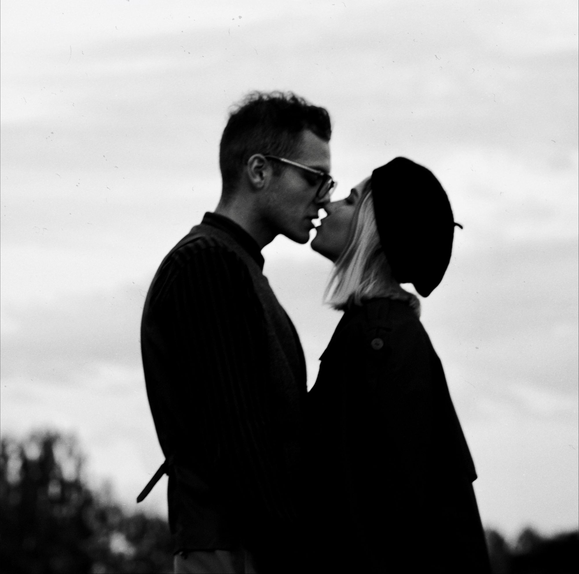 Foto preto e branco de casal apaixonado se beijando.