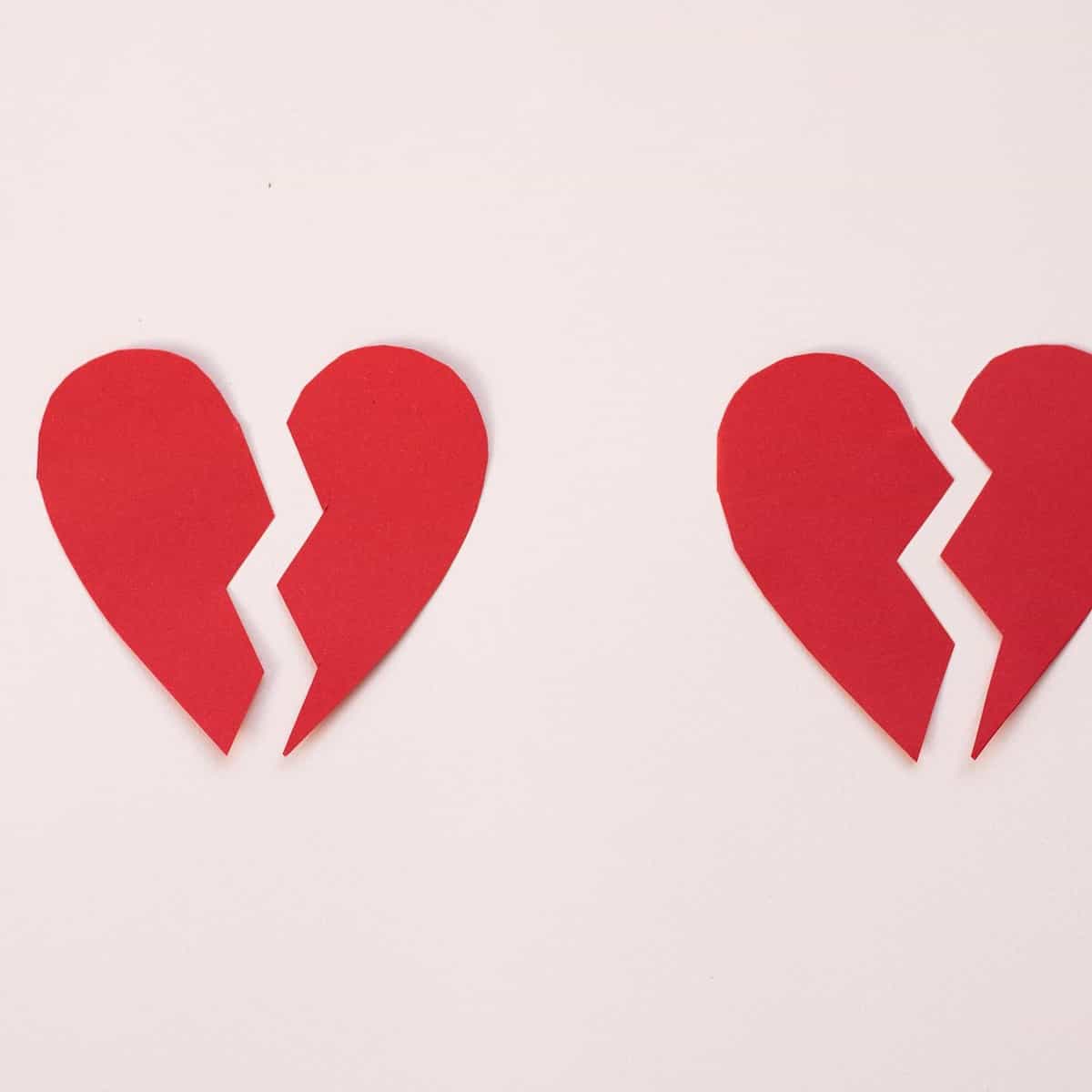 Foto de dois corações de papel partidos ao meio.