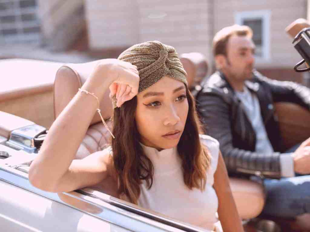 Primeiro ano de casamento: problemas comuns e como passar por eles - Casal-brigado-discucao-carro Casal brigado dentro do carro. Ela está com braço apoiado na janela do carro, veste uma blusa sem manga de gola alta branca e lenço cinza na cabeça. Enquanto ele está no lado do motorista de jaqueta de couro.