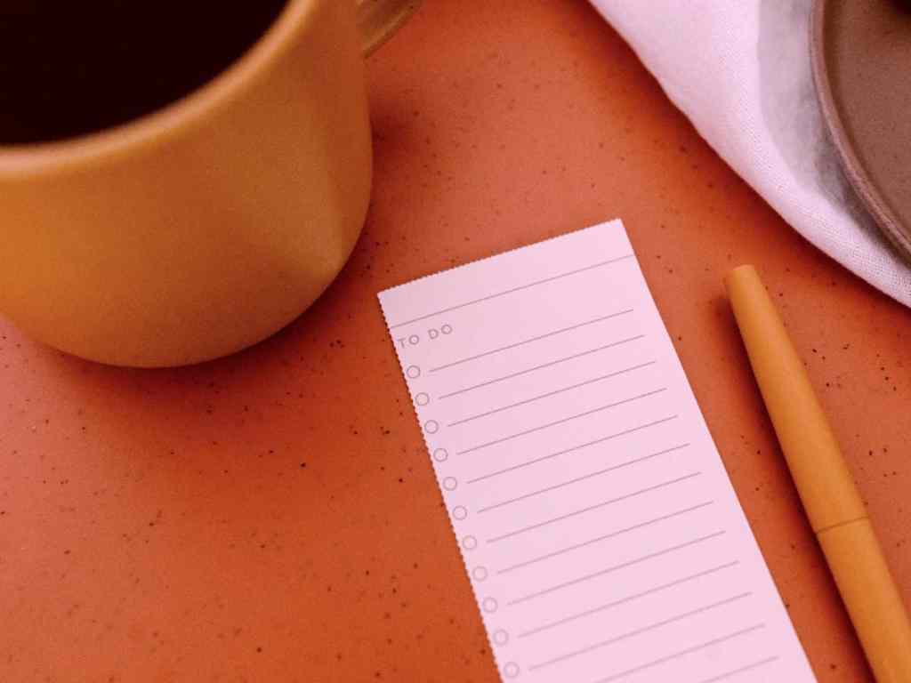 Lista em branco com o título "to do" do lado uma caneta e uma xícara.