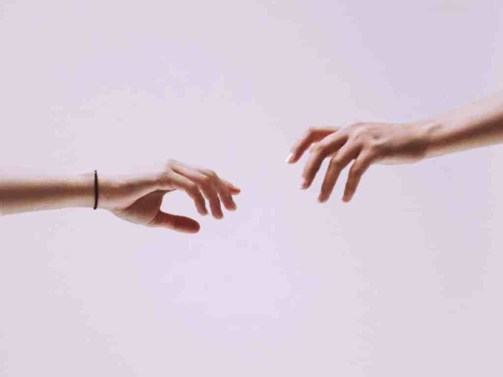 Por que é importante ter um tempo só para você no relacionamento? - Maos-quase-se-tocando Duas mãos se esticando para se tocar.