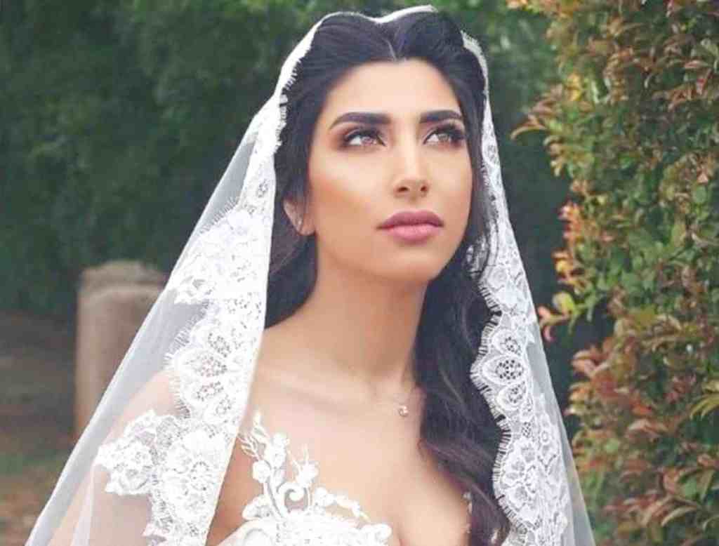 O que é uma mantilha? - Noiva-de-mantilha-veu Noiva olhando para cima, ela usa uma mantilha e vestido de noiva com alças rendadas.