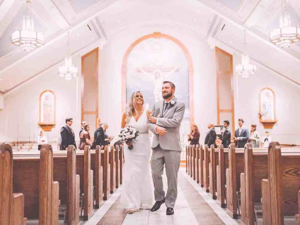 Noivo e noiva saindo da igreja.