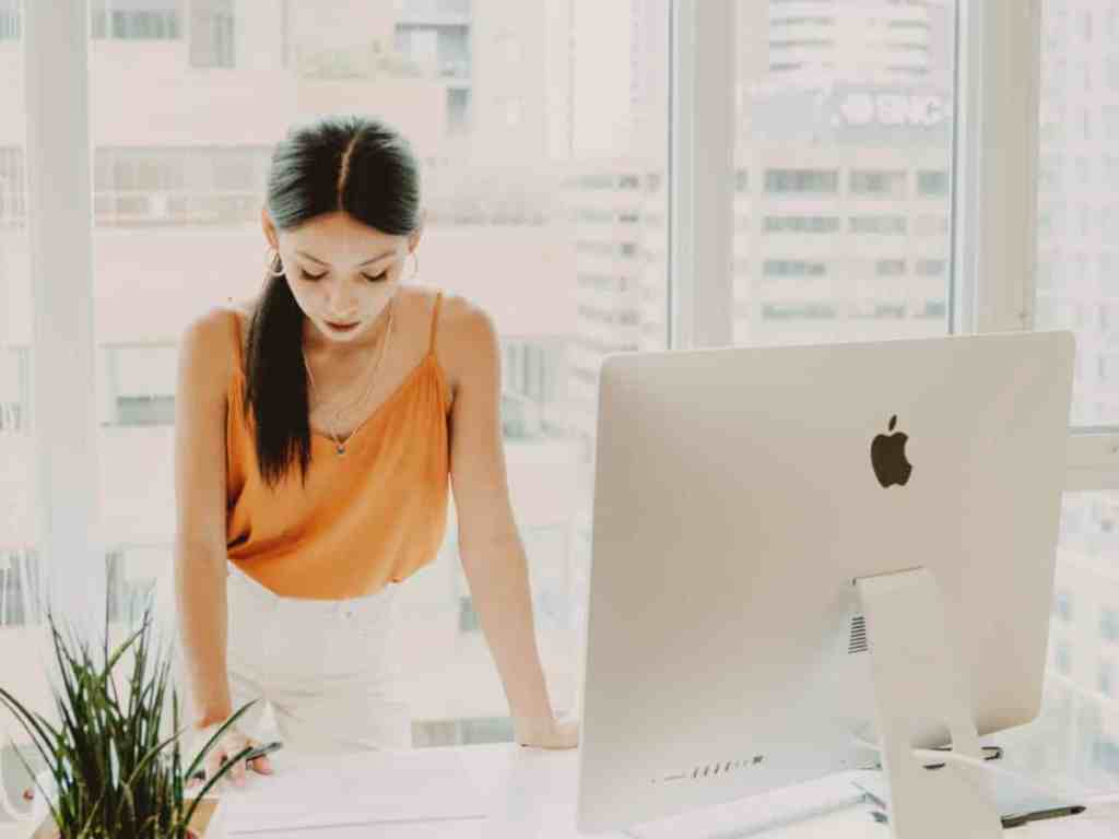 Qual a diferença de independência financeira e liberdade financeira? - Chefe-escritorio Mulher no escritório olhando para sua mesa.