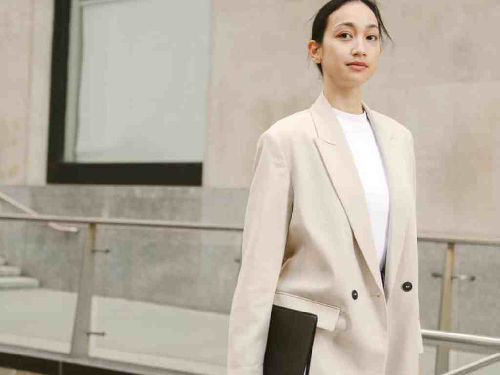 Quais as vantagens de ser uma empreendedora? - Empresaria-pasta Mulher de cabelo preso andando com um pasta.