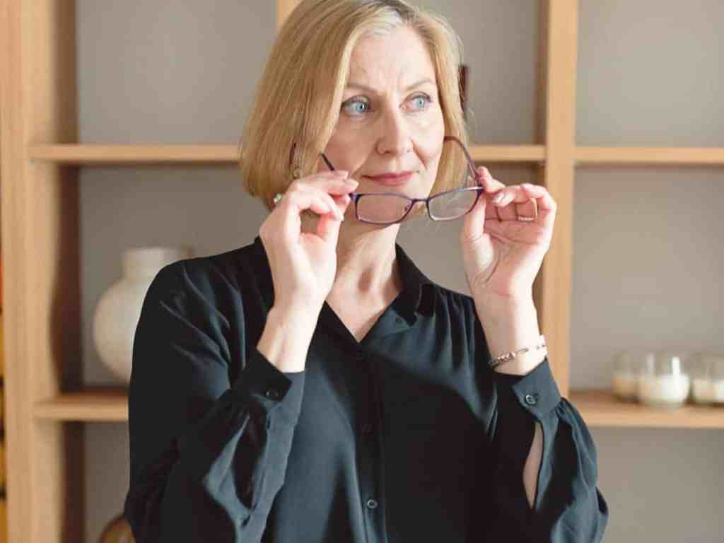 Quais as vantagens de ser uma empreendedora? - Empresaria-senhora Senhora no escritório colocando seus óculos