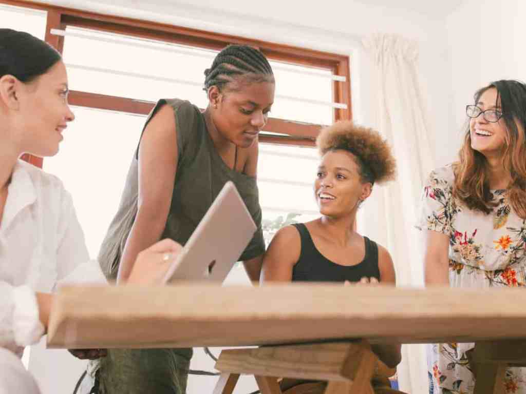 Quais as vantagens de ser uma empreendedora? - Time-equipe-feminina Equipe de mulheres sentadas em volta de uma mesa conversando.