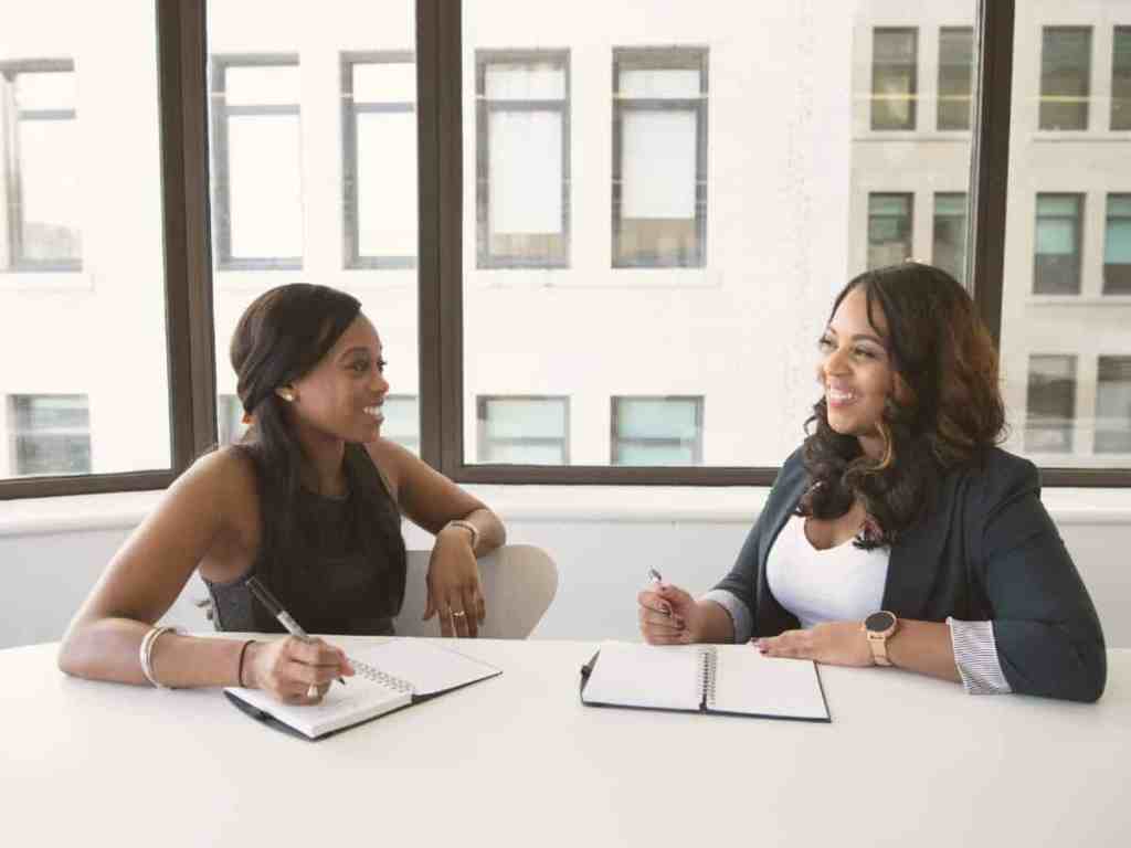 Duas mulheres de negócio conversando no escritório.