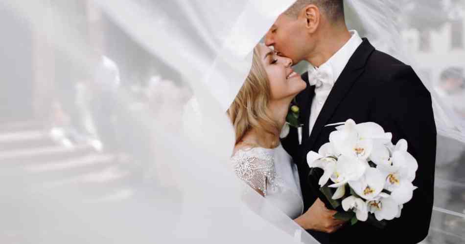 Noivos em um casamento, metade da foto é tampada por um véu de noiva