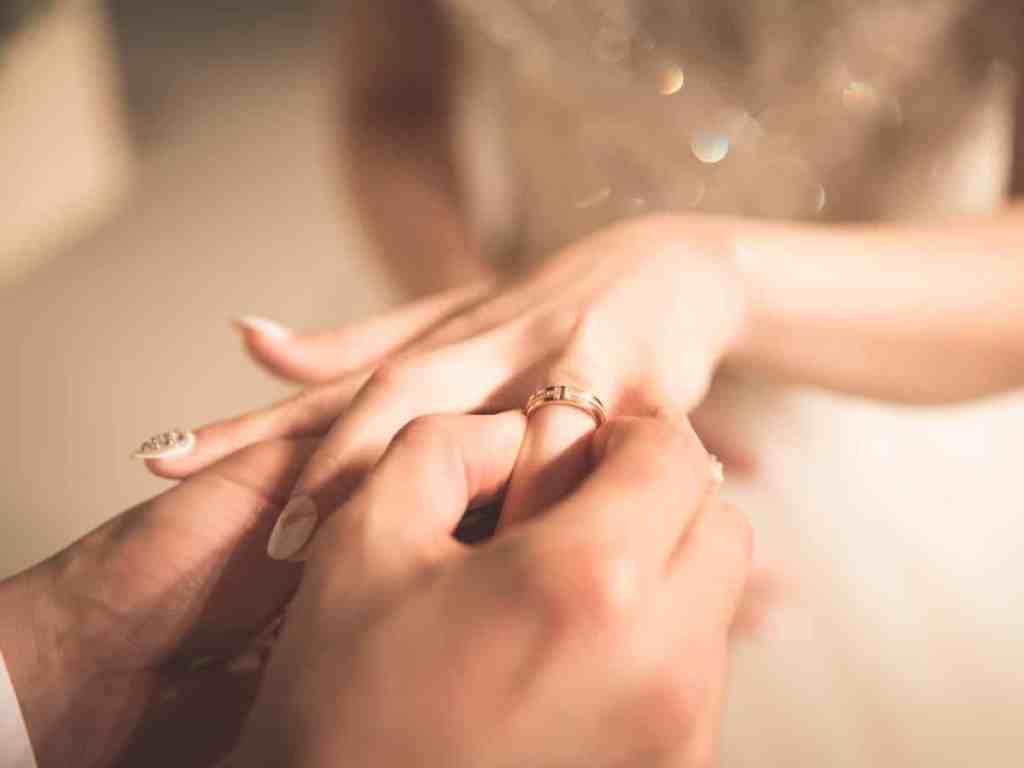 Colocando aliança no dedo da noiva.