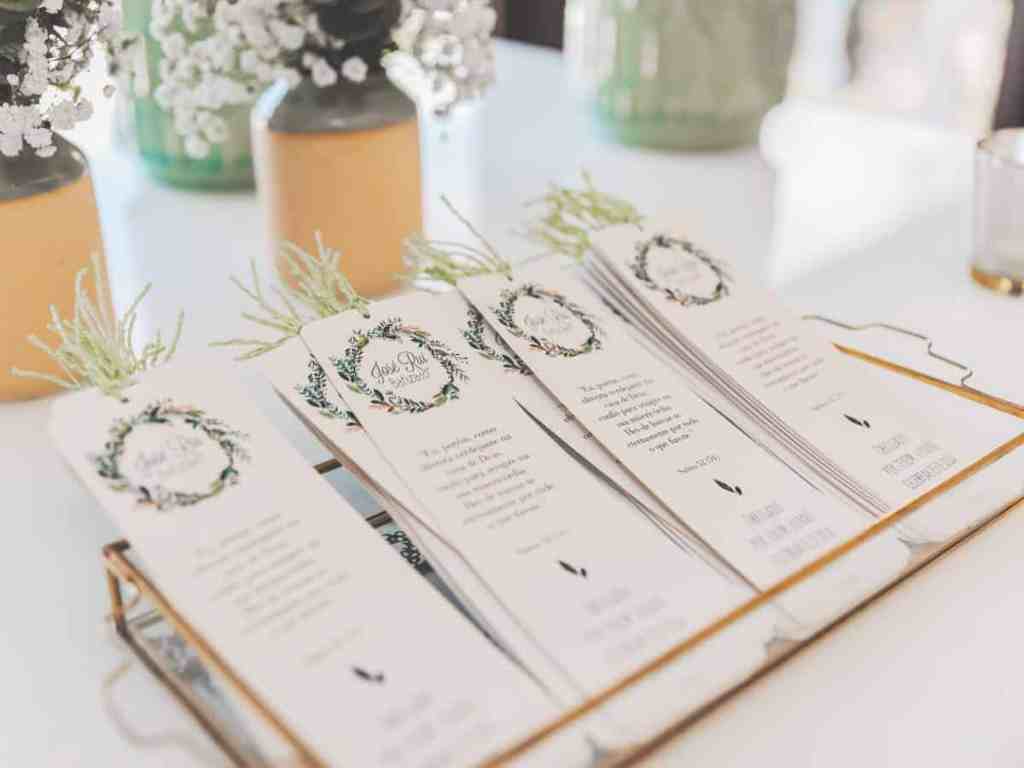 Convites de casamento dentro de uma bandeja transparente em cima da mesa.