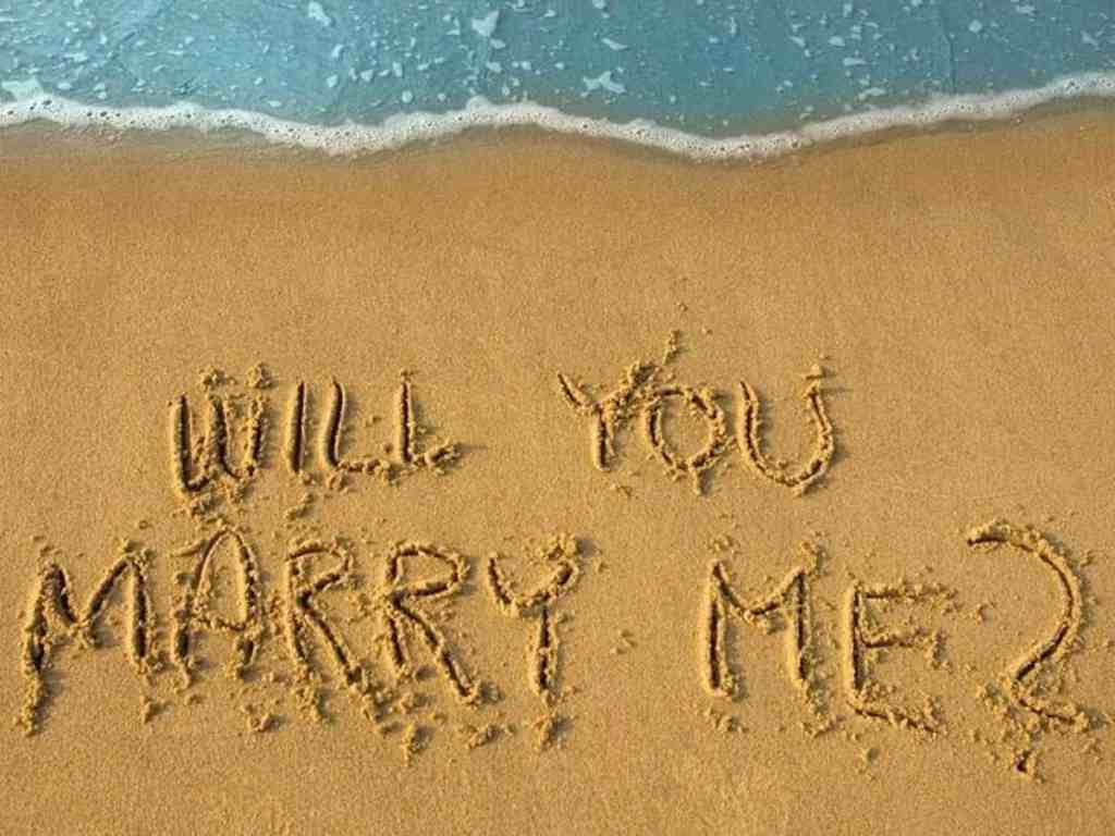 Escrito "casa comigo? " em inglês na areia
