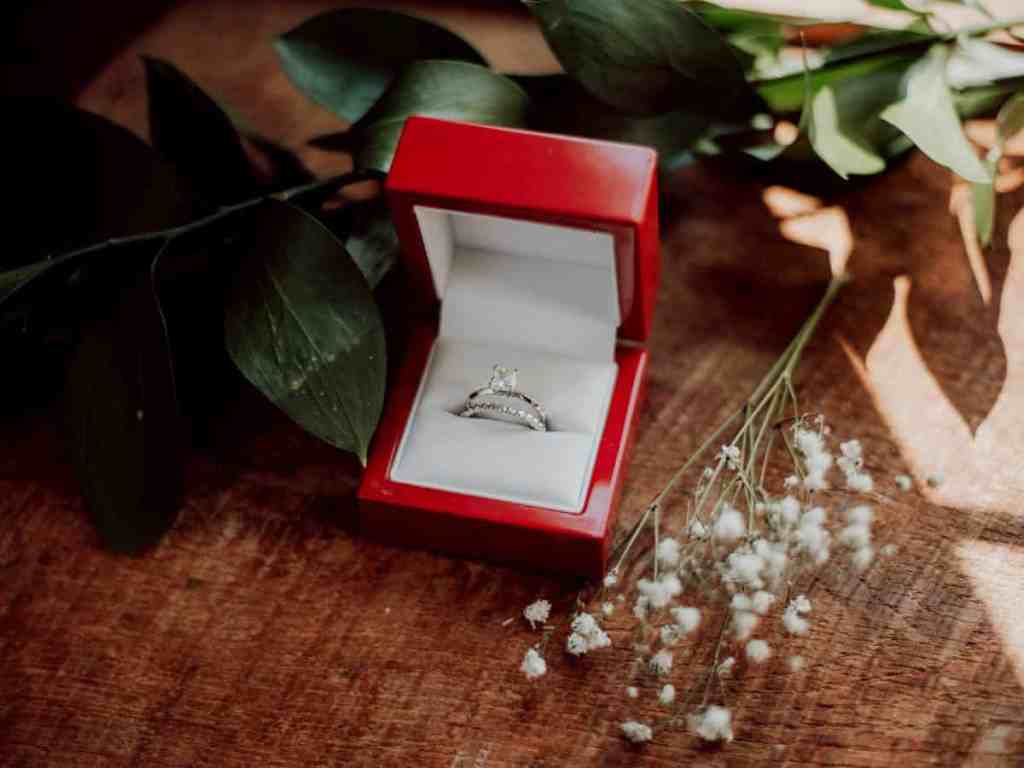 Aliança de Casamento: Tudo o que o você precisa saber para comprar a sua Online - Anel de noivado solitario Caixinha vermelha de alianças, com um anel solitário e uma meia aliança dentro.