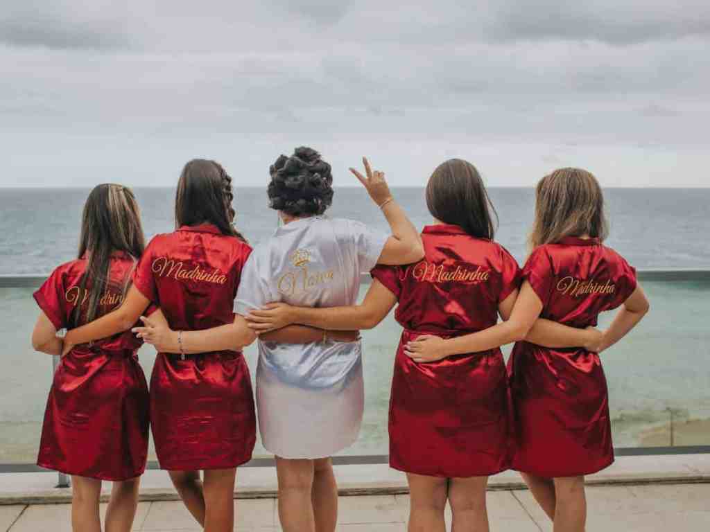 Noiva e madrinhas de frente para o mar