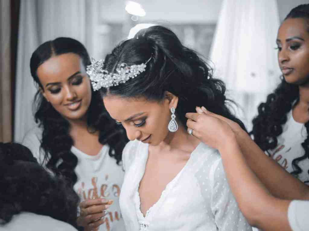 Noiva se arrumando para o casamento com ajuda das madrinhas
