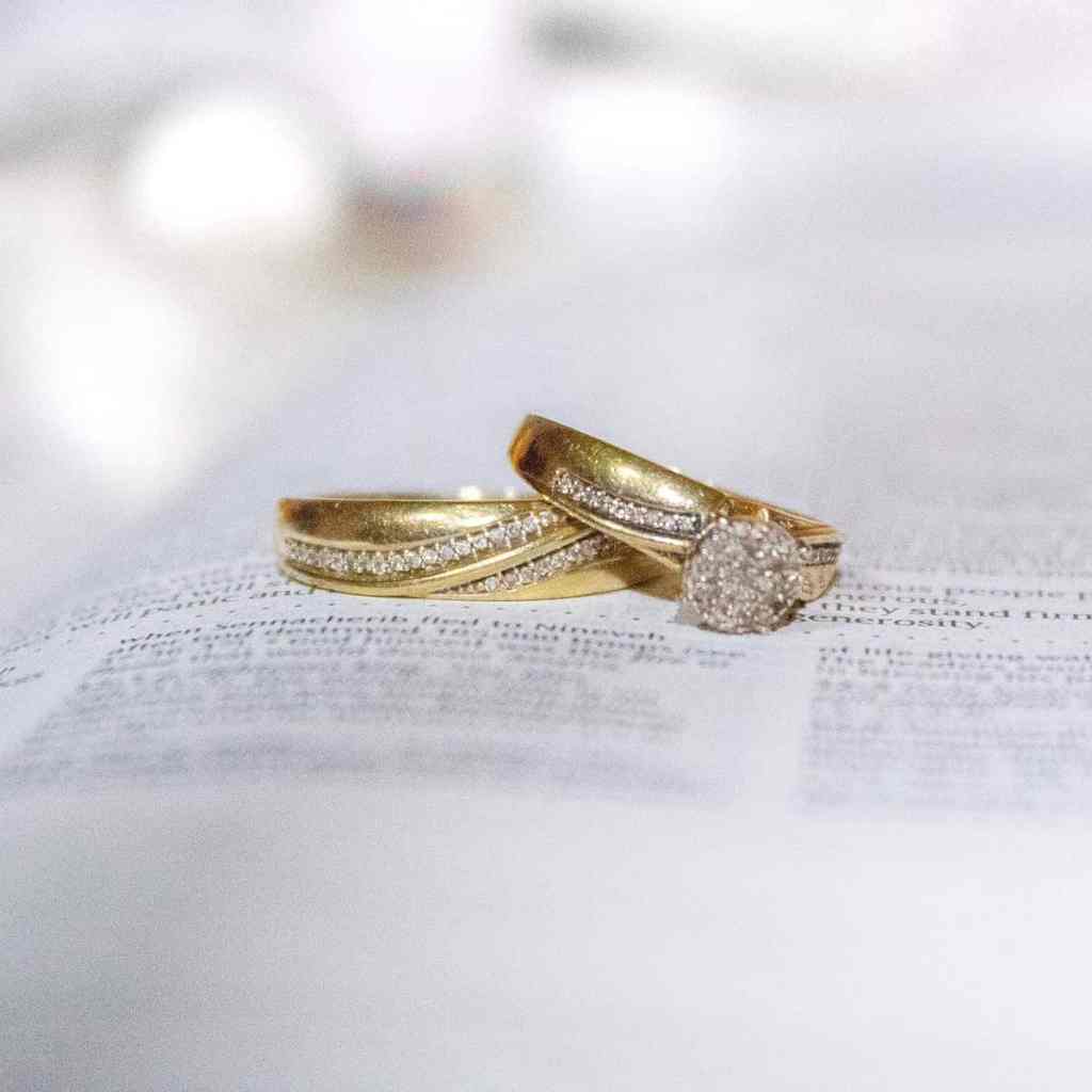 Frases legais para gravar na aliança de casamento - Aliancas-biblia Par de alianças em cima de uma página da bíblia