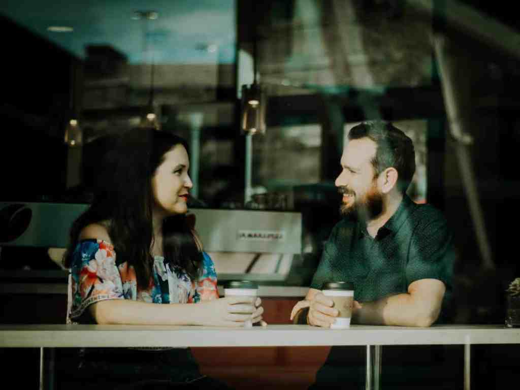 Casal conversando sentados em uma cafeteria