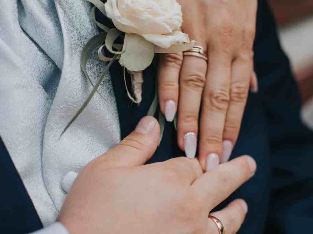 Imagem mostrando a aliança na mão dos noivos