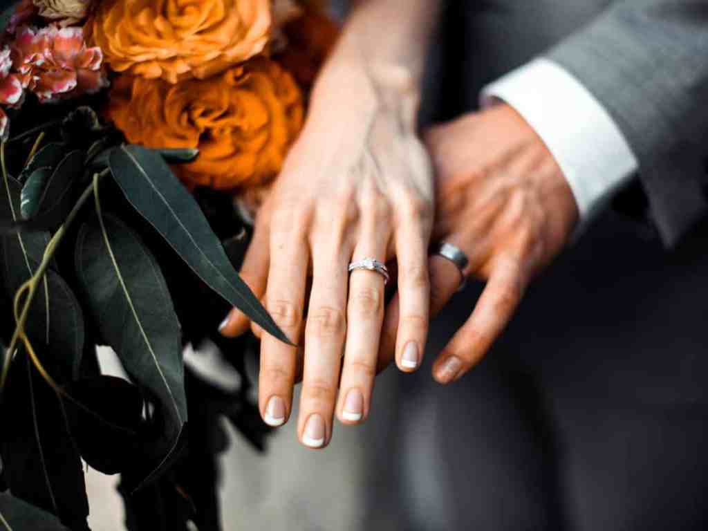 Mãos do casal com suas alianças na cor prata