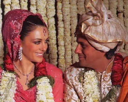 20 casamentos mais caros da história - Casamento-elizabeth-hurley-arun-nayar-2 Casamento de elizabeth hurley e arun nayar. Eles estão sorrindo olhando um para o outro, com roupas típicas indianas. A roupa de noiva dela é rosa