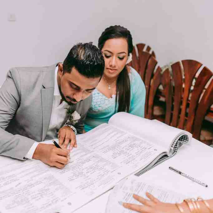 Quanto custa um casamento no Brasil e no mundo? - Noivos-casando-no-civil Noivos assinando os documentos em seu casamento no civil, onde o custo do casamento é mais barato.