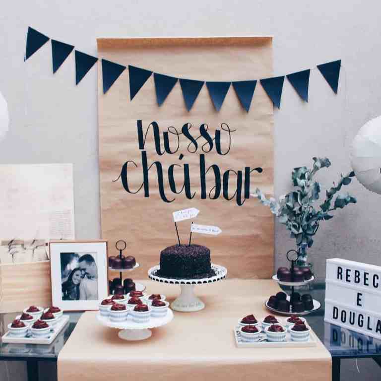 O chá bar- com bolos e doces em cima da mesa, junto com o nome dos noivos