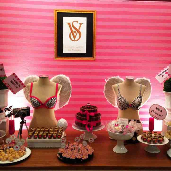 Imagem de um chá de lingerie, nela tem uma mesa com os doces e dois manequins usando sutiãs
