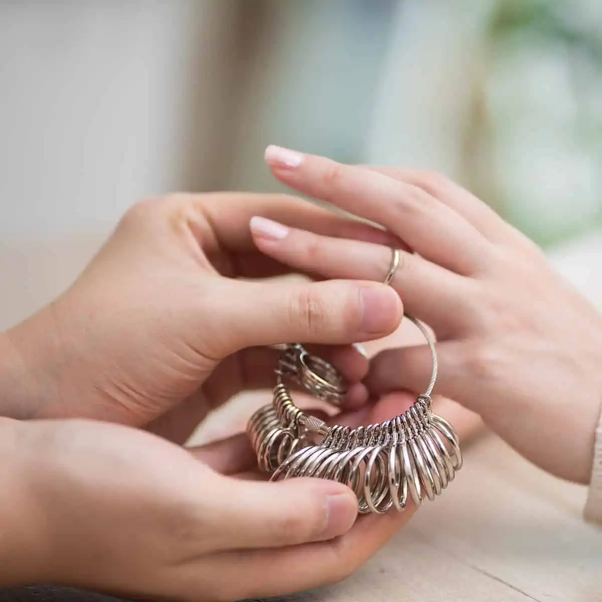 Homem medindo o dedo da mulher com aneleira de metal
