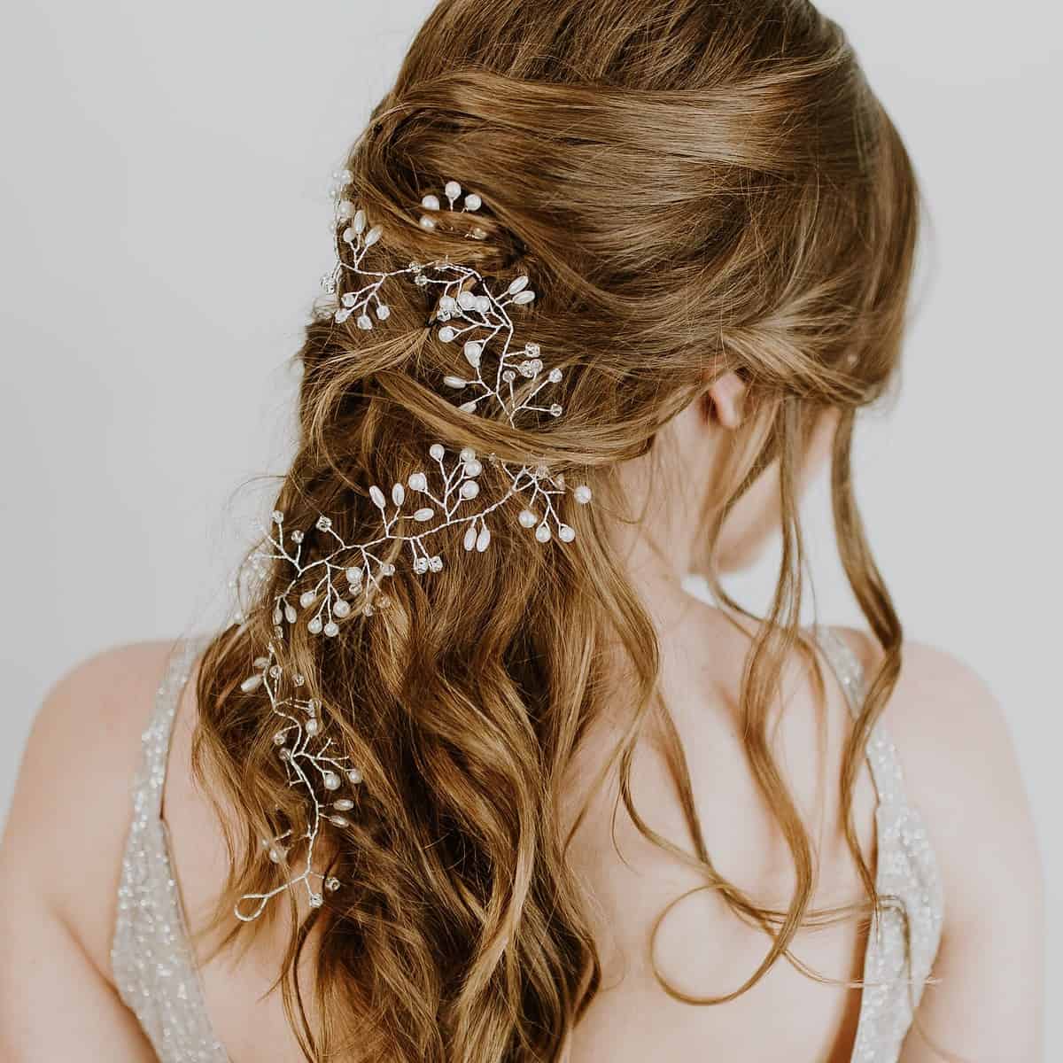 Noiva de costas, mostrando seu penteado com flores pequenas.