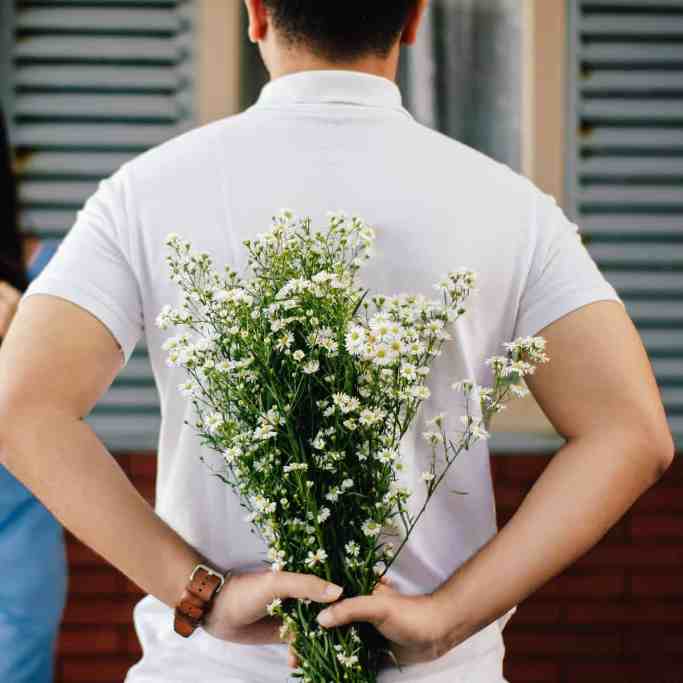 O que dizer ao entregar a aliança? - Como fazer pedido de casamento 3 Homem com buquê de flores escondido para entregar para namorada