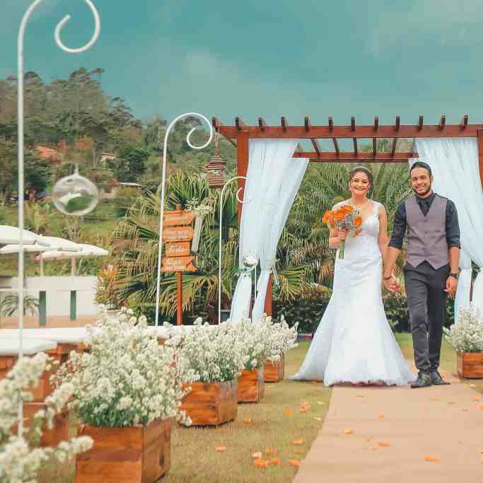 Despesas do casamento: quem paga o que? - Despesas do casamento Noivos de mãos dadas em casamento ao ar livre