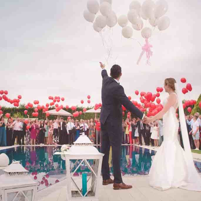 Como lidar com cancelamentos dos fornecedores no casamento? - Fornecedores casamento 1 Noivos na festa de casamento ao ar livre, ao lado de uma piscina, onde foram soltados vários balões