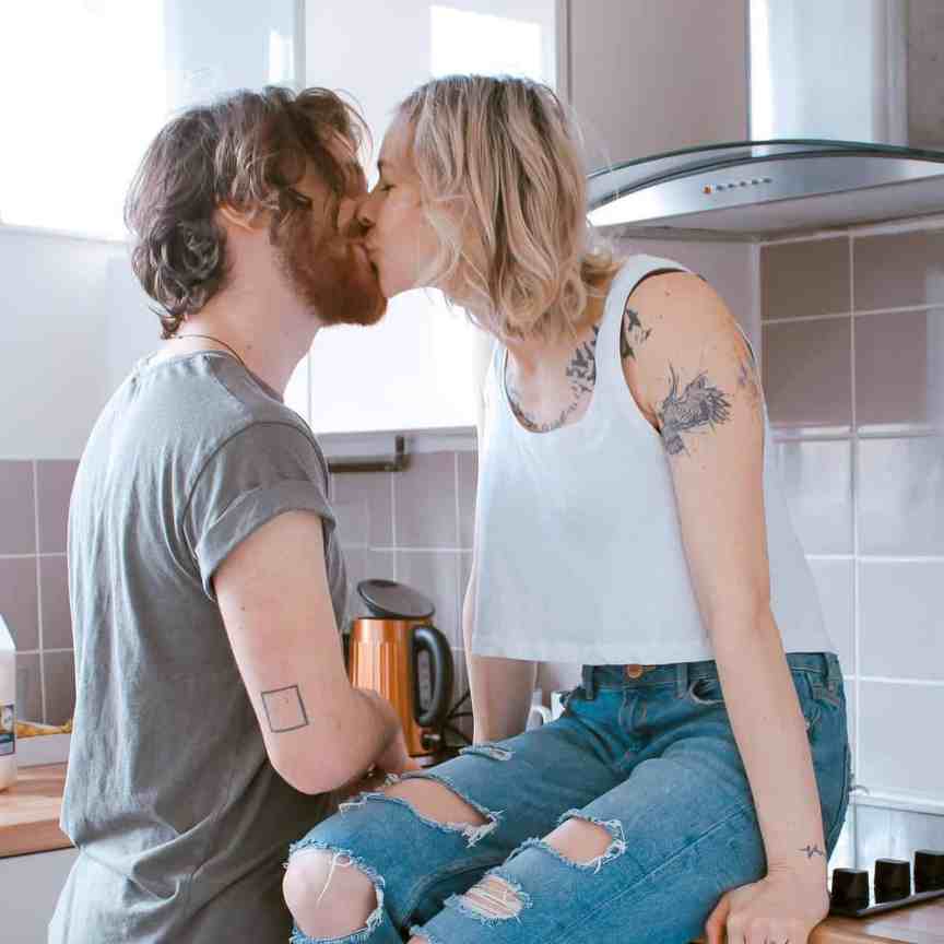 Noite de Jogos em Casal: Os melhores jogos para sair da rotina - Jogos de casal 1 Casal se beijando na cozinha