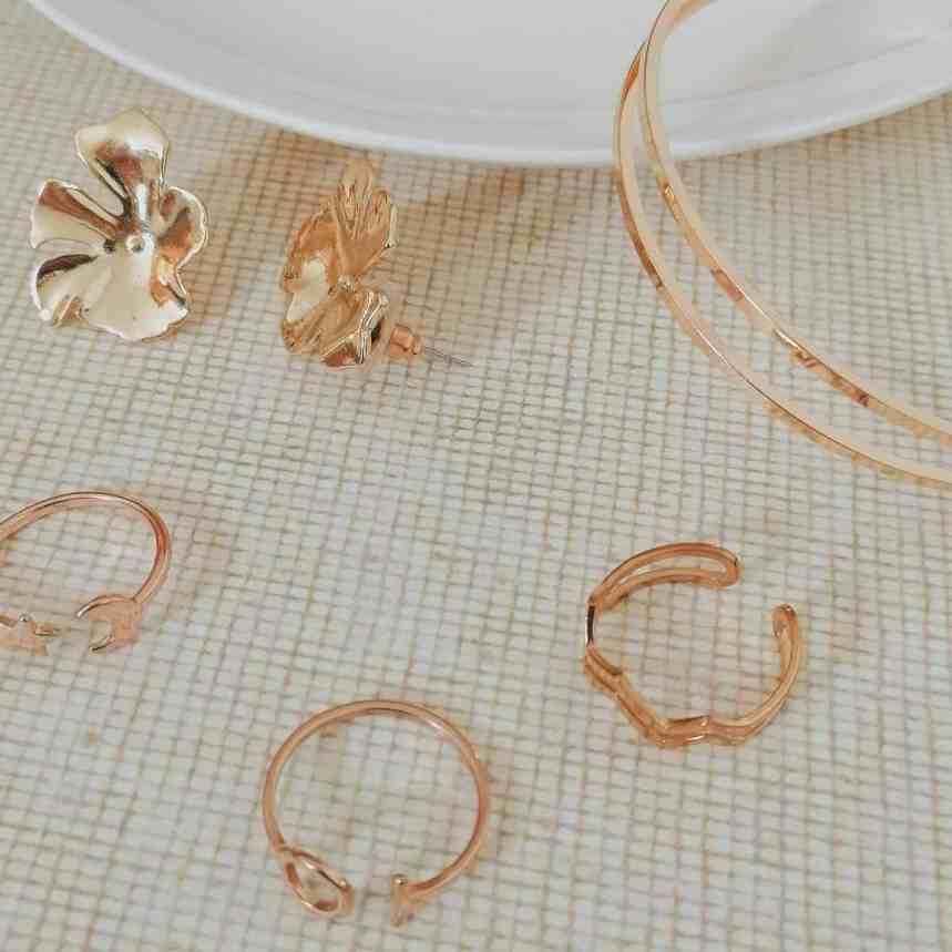 5 Formas de Organizar suas Joias e Semijoias - Joias semijoias Joias na cor dourada e rosé sobre uma mesa