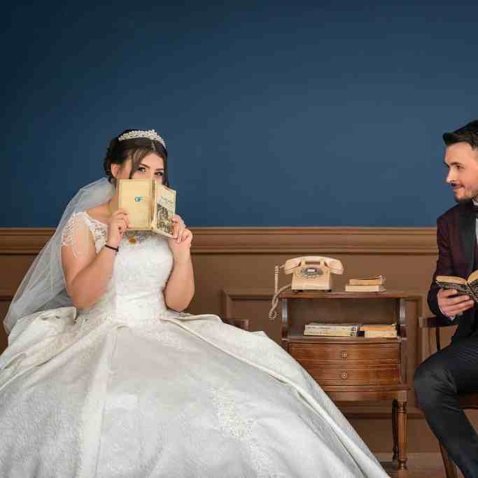 Poses para Fotos de Casamento e Noivado - Noivos sentados Noivos sentados com livro na mão posando para foto