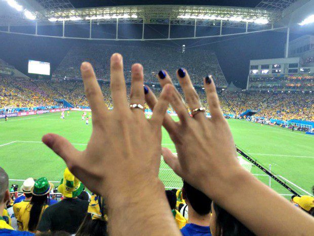 Copa do mundo: como fazer o pedido de casamento? - Pedido 2 Pedido de casamento em estádio, os noivos estão mostrando as alianças