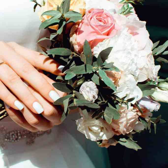 Despesas do casamento: quem paga o que? - Quem paga o casamento 3 Noiva segurando buquê de casamento onde é possível notar sua aliança de ouro fina