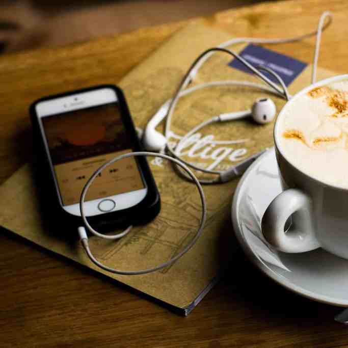 Mesa com café, celular e livro - 15 coisas que você precisa saber antes de fazer o pedido de casamento