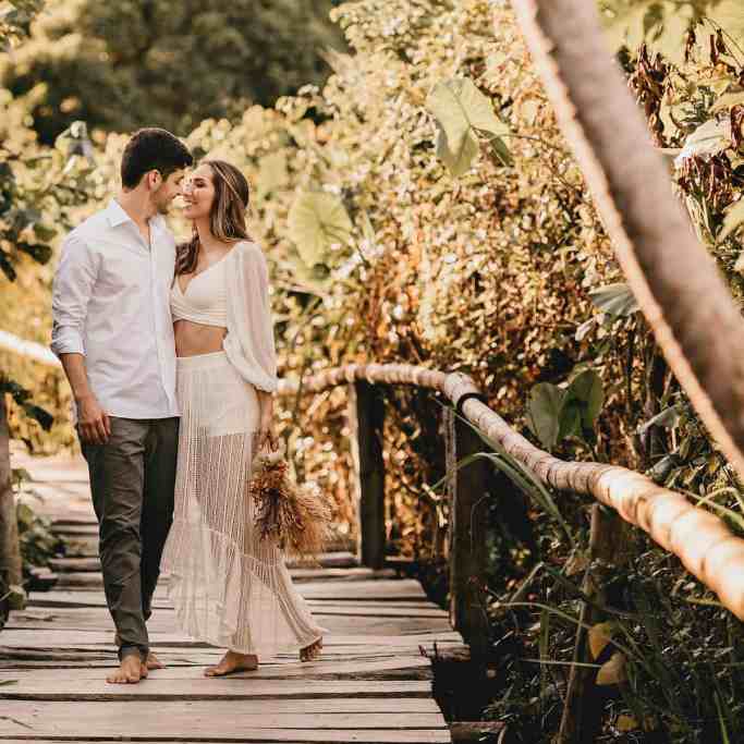 Casal em pé em uma ponte abraçados