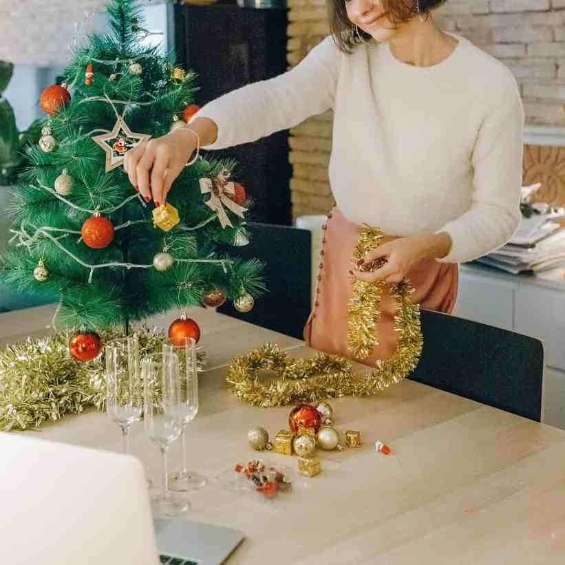 Existe amor nos aplicativos de relacionamento? - Relacionamentoapaplicativo 10 Mulher decorando árvore de natal enquanto faz vídeo chamada no notebook