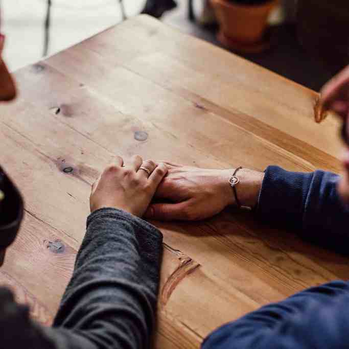 Existe amor nos aplicativos de relacionamento? - Relacionamentoapaplicativo 2 Casal de mãos dadas sobre a mesa de madeira