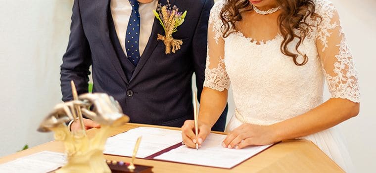 Casal assinando os papéis do casamento