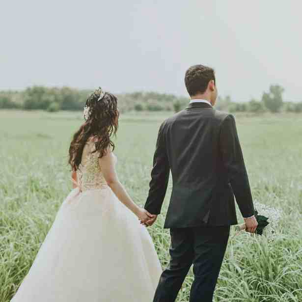 Tendências para Casamento 2023: Comece o Planejamento - Tendencia casamentos Noivos andando pela grama de mãos dadas
